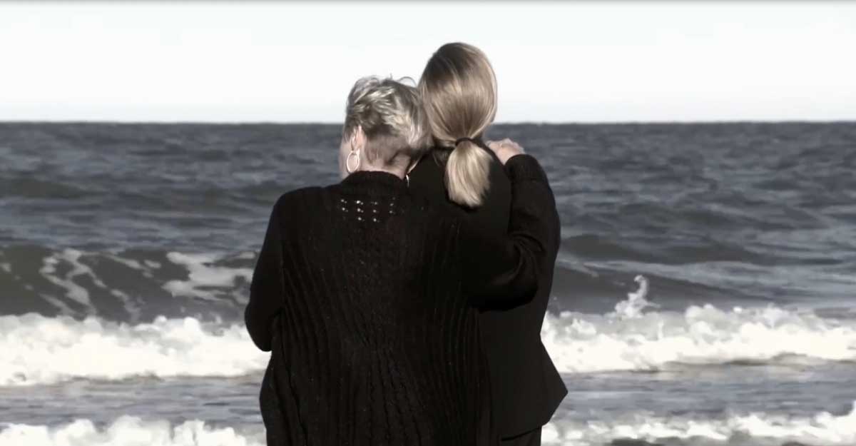 2 women hugging at seashore
